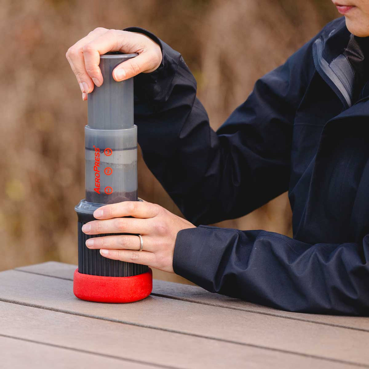 Woman brewing coffee with Aeropress Go
