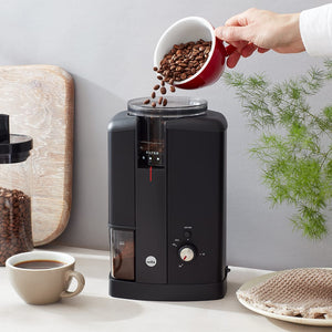 Pouring coffee beans into a Wilfa Svart Aroma coffee grinder